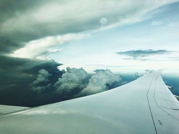 Airplane flying over clouds in sky