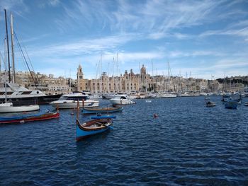 Sailboats moored in sea against sky