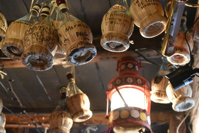 Low angle view of lighting equipment and bottles hanging at a restaurant