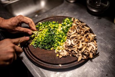 Cropped hands of chef chopping food on kitchen counter