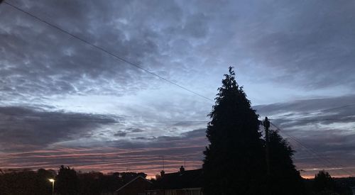 Low angle view of silhouette trees against sky at sunset