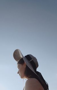 Portrait of woman wearing hat against clear sky