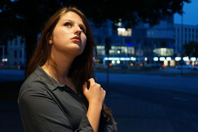 Woman standing on street at night