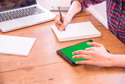 High angle view of woman using laptop on table at home