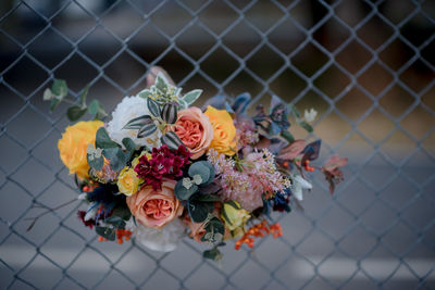 Close-up of rose bouquet on chainlink fence