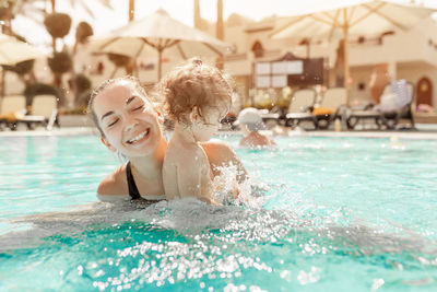 Mother and daughter swimming in pool