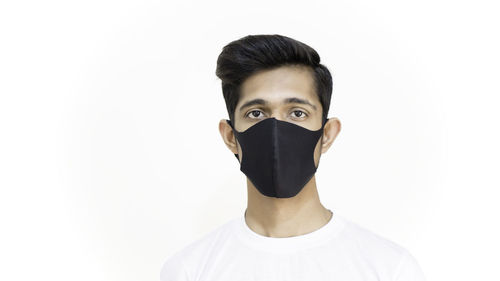 Portrait of young man standing against white background