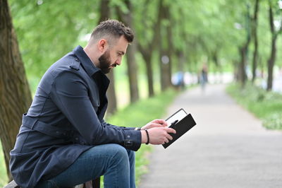 Side view of young man using mobile phone