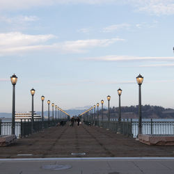 Street lights on bridge against sky