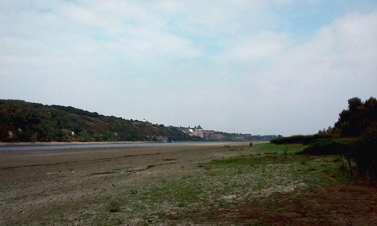 sky, tranquil scene, tranquility, water, scenics, tree, beauty in nature, nature, beach, landscape, cloud - sky, sand, cloud, shore, non-urban scene, sea, idyllic, grass, lake, day