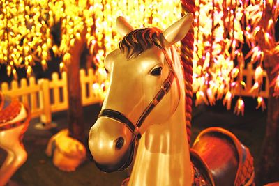 Carousel horse in amusement park at night