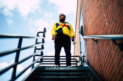 Man standing on staircase against sky