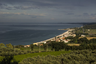 Scenic view of sea by town against sky