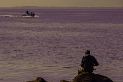 People on boat in sea against sky