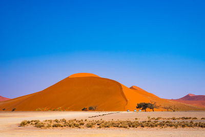 Scenic view of desert against blue sky