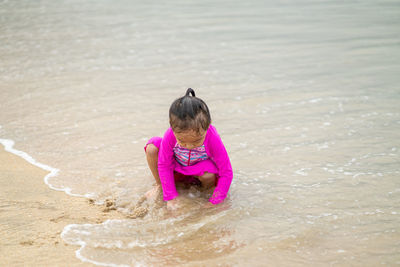 Full length of girl playing at beach