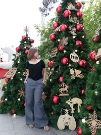 Woman standing by christmas tree