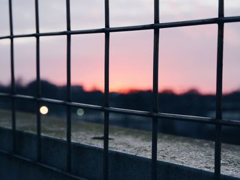 Close-up of railing against sky during sunset