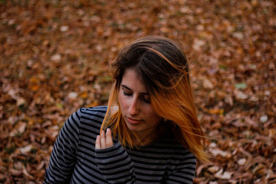 Close-up of a young woman with autumn leaves