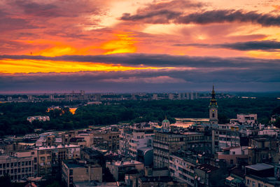 High angle view of city against cloudy sky during sunset