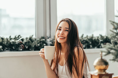 Portrait of a young woman drinking coffee