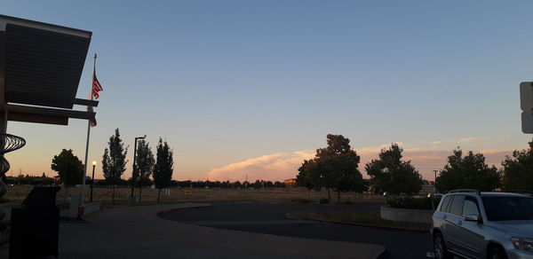 Cars on road against sky during sunset