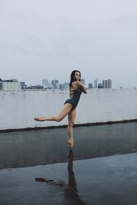 Side view of young woman standing in swimming pool