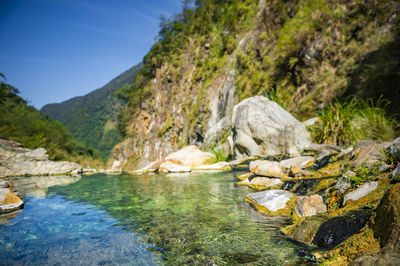 Scenic view of river by mountains against sky