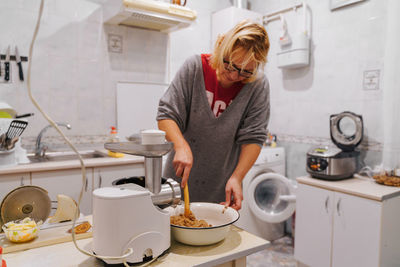 Mature woman preparing food in kitchen