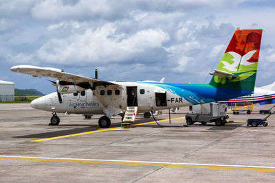 Airplane on airport runway against sky