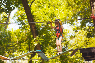 Low angle view of girl walking on rope