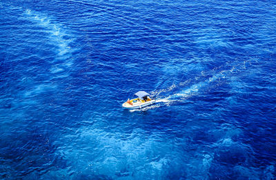 Aerial view tourists crowd at blue lagoon on a sunny summer day with boats on comino island, malta.