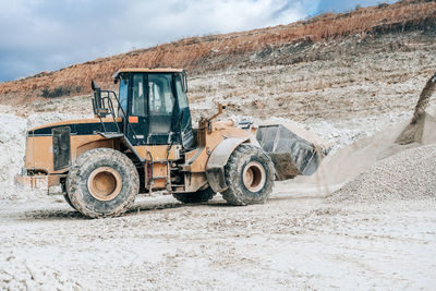 Wheel loader with large bucket on construction site or quarry. mining heavy machinery details. 