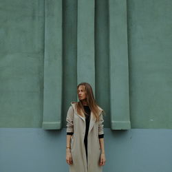 Full length of young woman against wall