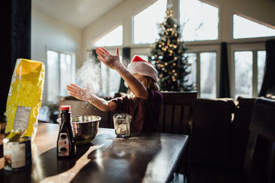 Boy doing christmas baking and playing with flour