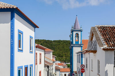 View of buildings in city against blue sky