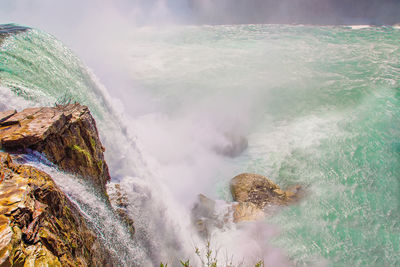 Panoramic view of sea waves breaking on rocks