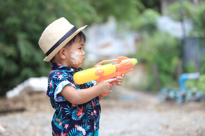 Full length of boy playing wit water gun