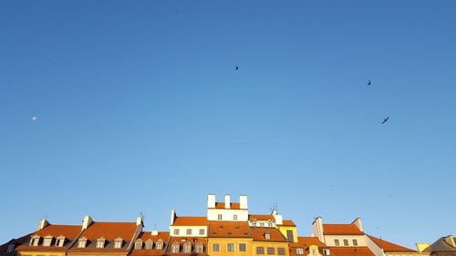 Low angle view of buildings against clear blue sky