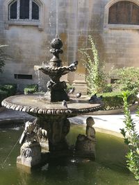 Statue by fountain in city