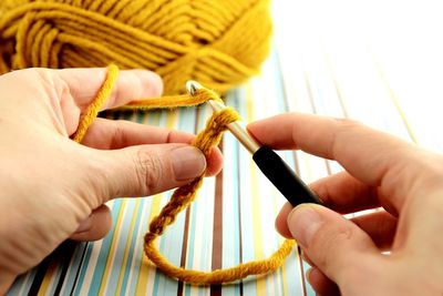 Cropped image of woman crocheting wool