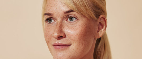 Close-up of young woman against pink background