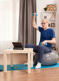 Man using mobile phone while sitting on sofa at home