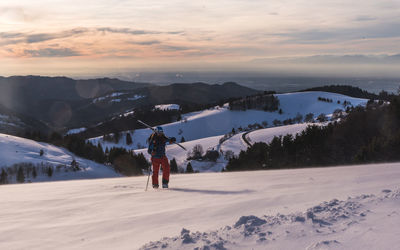 People on snowcapped mountain against sky during winter