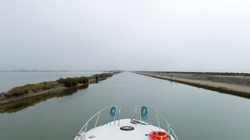 Boat in canal du rhone a sete against clear sky