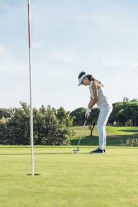 Full length of woman playing at golf course