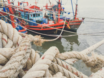 Tied up ropes against boats moored at harbor