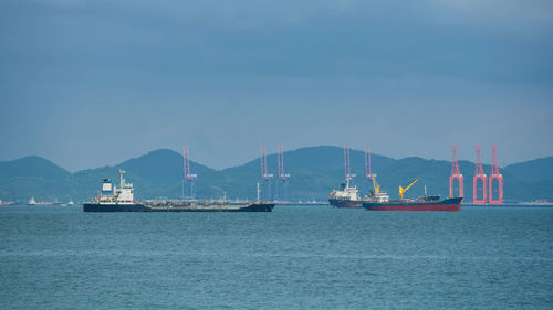 Boats in sea against clear sky