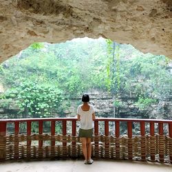 Rear view of woman standing by railing