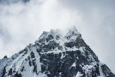 Low angle view of snowcapped mountain against sky